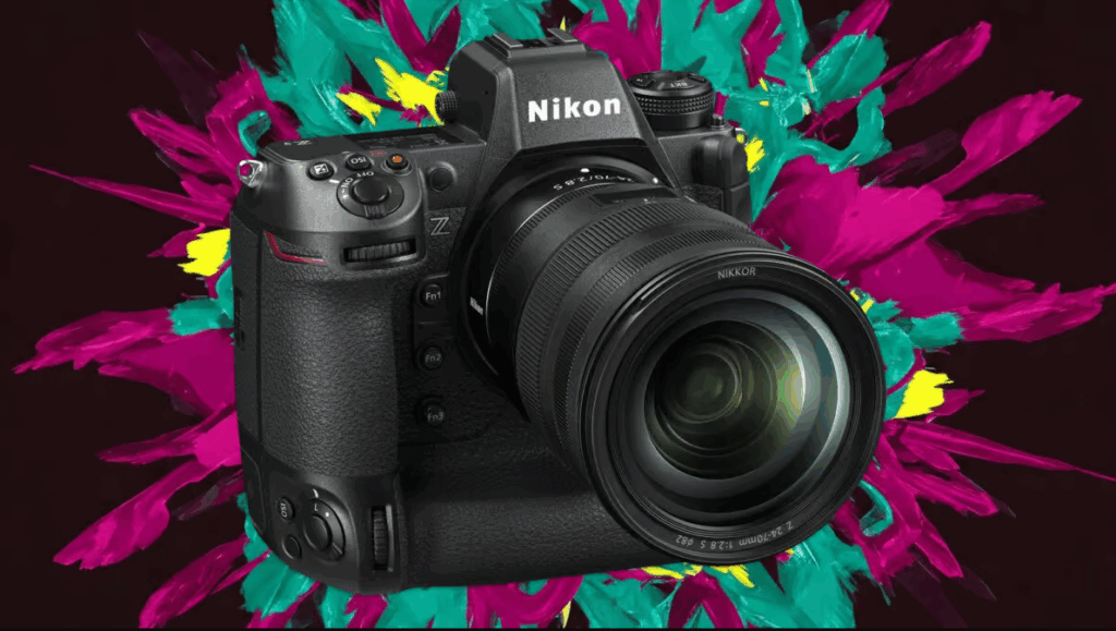 Nikon Z9 II 플래그십 미러리스 카메라가 밝은 색상의 추상적인 배경 앞에 강조되어 있으며, 장착된 NIKKOR Z 24-70mm f/2.8 S 렌즈와 견고한 바디 디자인이 돋보인다.
