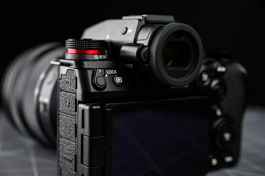 Panasonic Lumix S1 II의 EVF와 LOCK 스위치 근접 촬영. 뷰파인더와 상단 다이얼, 후면 회전 LCD 일부가 보인다.
