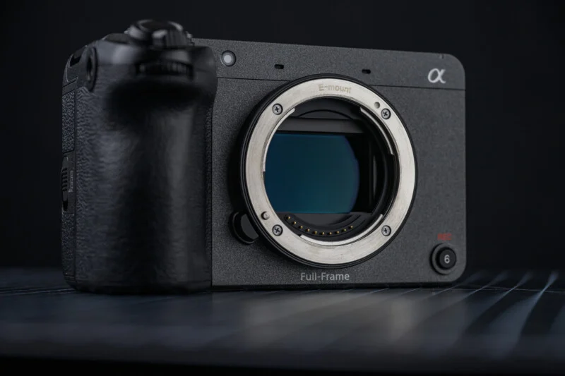 Sony FX2 카메라의 정면 클로즈업 이미지. E-마운트와 33MP 풀프레임 센서가 드러난 상태이며, 바디 우측 하단에는 빨간색 REC 버튼이 보인다.