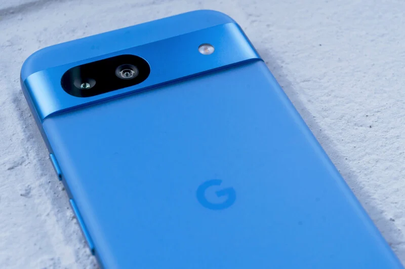 파란색 Google Pixel 8a의 후면이 클로즈업되어 있으며, 싱글 렌즈와 LED 플래시가 강조되어 있다.