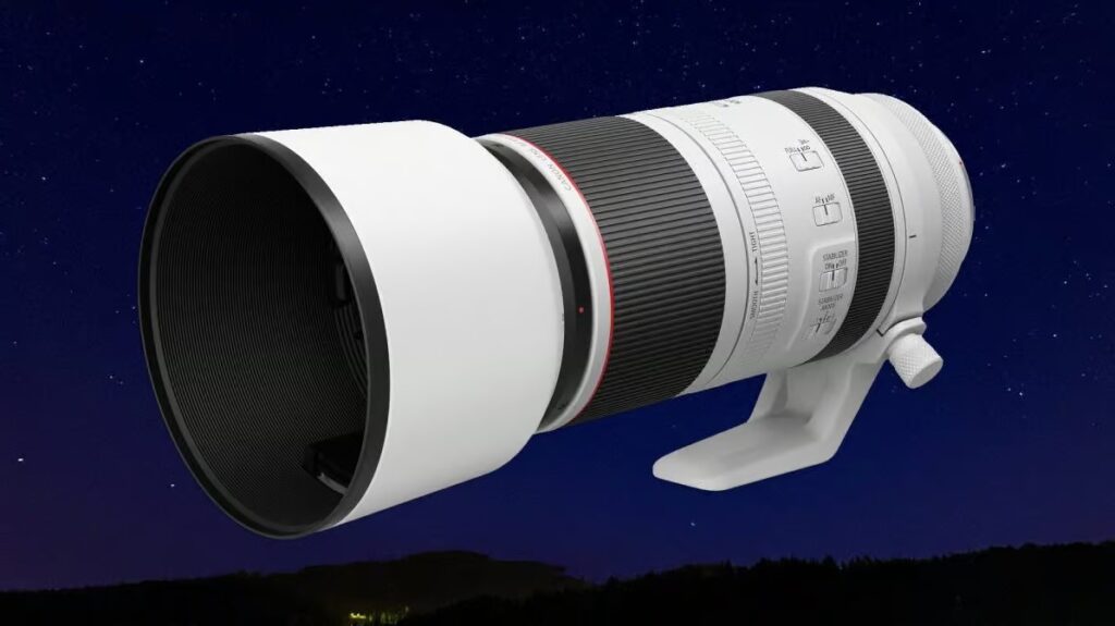 야경을 배경으로 한 캐논 RF 150-600mm f/5.6L IS USM 망원 줌 렌즈 렌더링 이미지, 후드가 장착된 상태로 보임