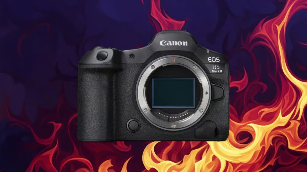 “불꽃 배경 위에 놓인 Canon EOS R5 Mark II 카메라. 렌즈 마운트 내부 센서가 노출되어 있으며, 고성능과 발열 이슈를 상징적으로 표현한 이미지.