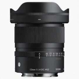 시그마 12mm f/1.4 DC DN 렌즈의 전면에서 바라본 모습입니다. 렌즈 후드가 장착되어 있으며, 렌즈 경통에는 촘촘한 링 패턴과 조리개 값 표시, '12mm 1:1.4 DC ø62' 문구와 시그마 로고가 인쇄되어 있습니다. 렌즈 마운트 부분도 일부 보입니다.