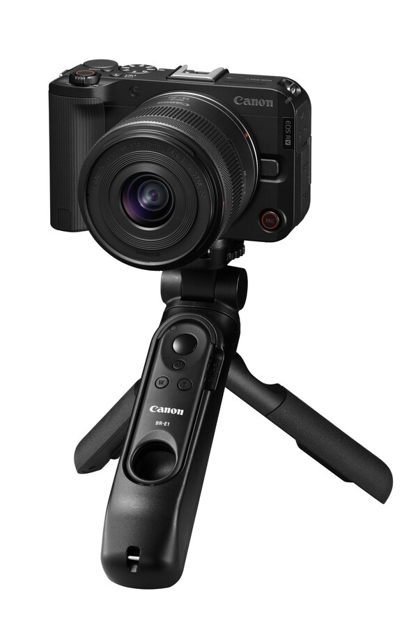 "캐논 EOS R50 V 미러리스 카메라와 14-30mm 렌즈 키트, 그리고 BR-E1 핸드그립 삼각대가 장착된 제품 이미지. 유튜버 및 브이로그 콘텐츠 제작자용 영상 특화 장비."