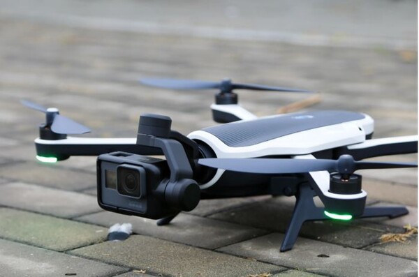 "GoPro 액션캠이 장착된 Karma 드론이 지면 위에 착륙해 있는 모습. 드론 전면에는 짐벌이 탑재되어 있으며, 프로펠러에는 녹색 LED 라이트가 점등돼 있다."