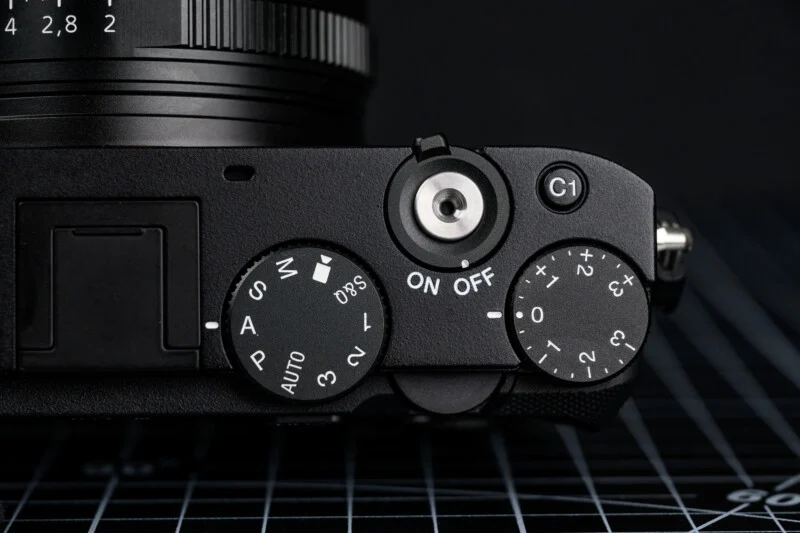 Sony RX1R III의 상단 다이얼 클로즈업, 전원 스위치 및 노출 보정 다이얼이 보이는 사진