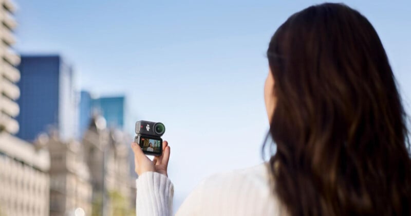 도심 야외에서 DJI Osmo Nano 액션카메라로 브이로그 촬영하는 여성