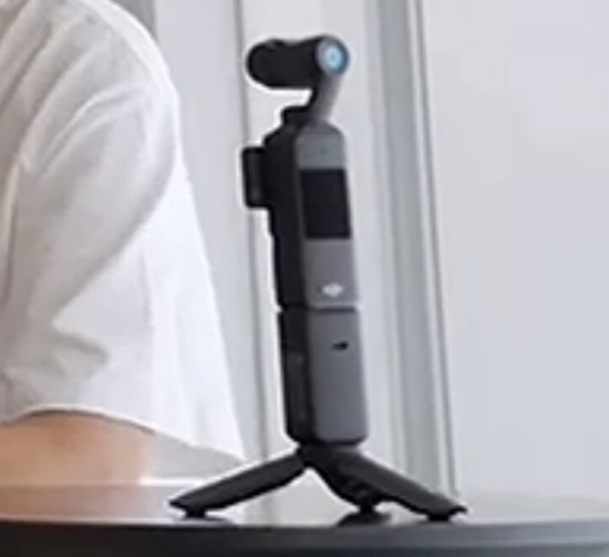 DJI Osmo Pocket 4 삼각대에 거치된 모습, 전면 디스플레이와 휴대용 짐벌 카메라 디자인