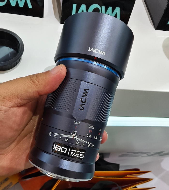 Lawoa AF 180mm f4.5 Macro 렌즈를 손에 들고 있는 모습 – 콤팩트한 디자인과 1.5배 매크로 배율 지원