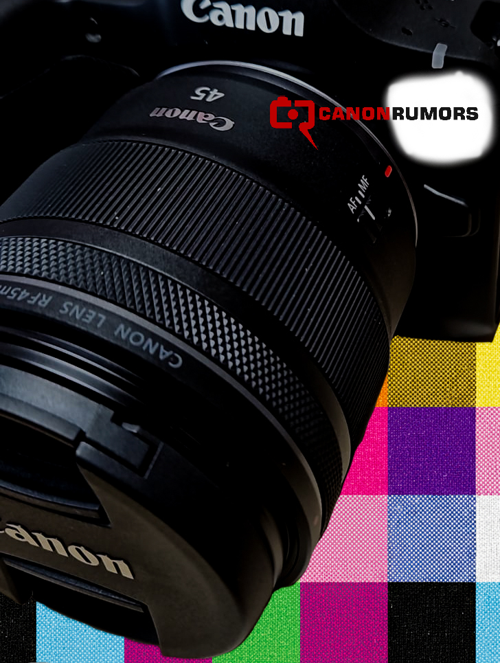 캐논 EOS 카메라에 장착된 RF 45mm f/1.2 STM 렌즈의 클로즈업 이미지. 렌즈의 초점 전환 스위치(AF/MF)가 보이며, 배경에는 컬러 체크 패턴이 깔려 있다. 상단에는 CanonRumors 로고가 추가되어 있으며, 제품 유출 이미지를 연상시키는 구도다.