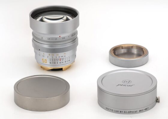 DJ-Optical 50mm f/1.0 Leica M 마운트 렌즈 본체와 전용 메탈 렌즈캡, 후드, 보호캡이 함께 놓여 있는 제품 구성.
