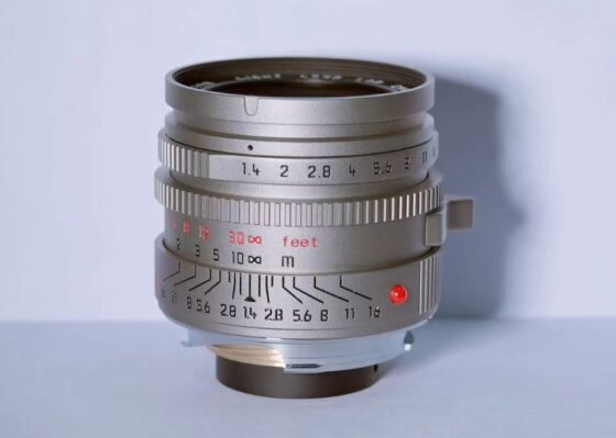 티타늄 그레이 색상으로 마감된 Light Lens Lab 35mm f/1.4 Aspherical “11873” 렌즈. 붉은 색상 포인트와 조리개, 초점 거리 눈금이 정교하게 새겨져 있으며, 고전적인 Leica 스타일 디자인을 재현한 모습이다.